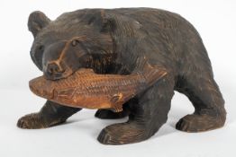 A Black Forest style carved wood model of a bear and salmon,