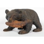 A Black Forest style carved wood model of a bear and salmon,