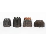 Four Victorian metal jelly moulds, including a castle shaped example (stamped C/393),