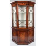 A reproduction George III style mahogany glazed display cabinet, of canted D-section,