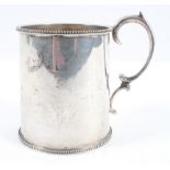 A plain form silver mug, with slightly shaped body with bead edge rim and foot and a scroll handle,