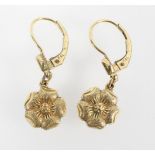 A yellow metal pair of drop earrings of floral design. Stamped 14ct.ro. Tests indicate gold plated.
