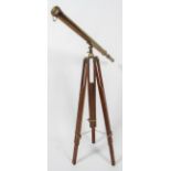 A 20th century three draw brass telescope, on wooden tripod stand, with chained dust cap,