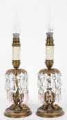 A pair of Empire style gilt metal lamps, on fish feet, with glass lustres,