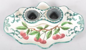 A Wemyss Ware inkstand, painted with red cherries, of scroll outline,