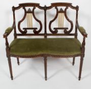 A Regency style two seat canape, with lyre back rests, serpentine seat and tapering fluted legs,