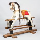 An early 20th century Galloper rocking horse, the horse with dappled grey body, glass eyes,