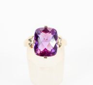A yellow metal single stone ring set with a cushion faceted chequerboard cut amethyst.