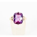 A yellow metal single stone ring set with a cushion faceted chequerboard cut amethyst.