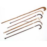 Four walking sticks with silver collars, together with a horn handled walking stick and another,