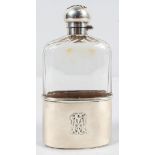 A panel cut glass hip flask with silver bayonet catch, silver top and pull off stirrup cup,