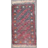 A claret ground wool prayer mat, woven with interlocking diamonds enclosing foliate motifs,