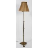 An Edwardian brass standard lamp, the adjustable stem with gadrooned ornament,