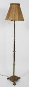 An Edwardian brass standard lamp, the adjustable stem with gadrooned ornament,
