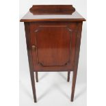 An Edwardian style pot cupboard, of plain form, with panel door, raised on slightly tapered legs,