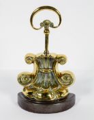 A Victorian brass and lead filled door stop, circa 1880, with a D-shaped handle,
