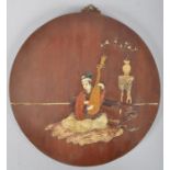 A Chinese wooden circular plaque inlaid with stone and marble with a figure playing a lute