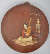 A Chinese wooden circular plaque inlaid with stone and marble with a figure playing a lute