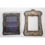 A wood backed silver photograph frame, of shaped form, decorated with scrolling foliates,