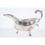 A silver sauce boat, with heavy cut card edge and an acanthus flying scroll handle,