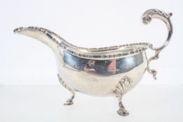 A silver sauce boat, with heavy cut card edge and an acanthus flying scroll handle,