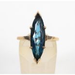 A yellow metal single stone ring. Set with a marquise cut synthetic blue spinel.