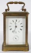 A French brass carriage clock, the enamelled dial with Roman numerals and subsidiary alarm dial,
