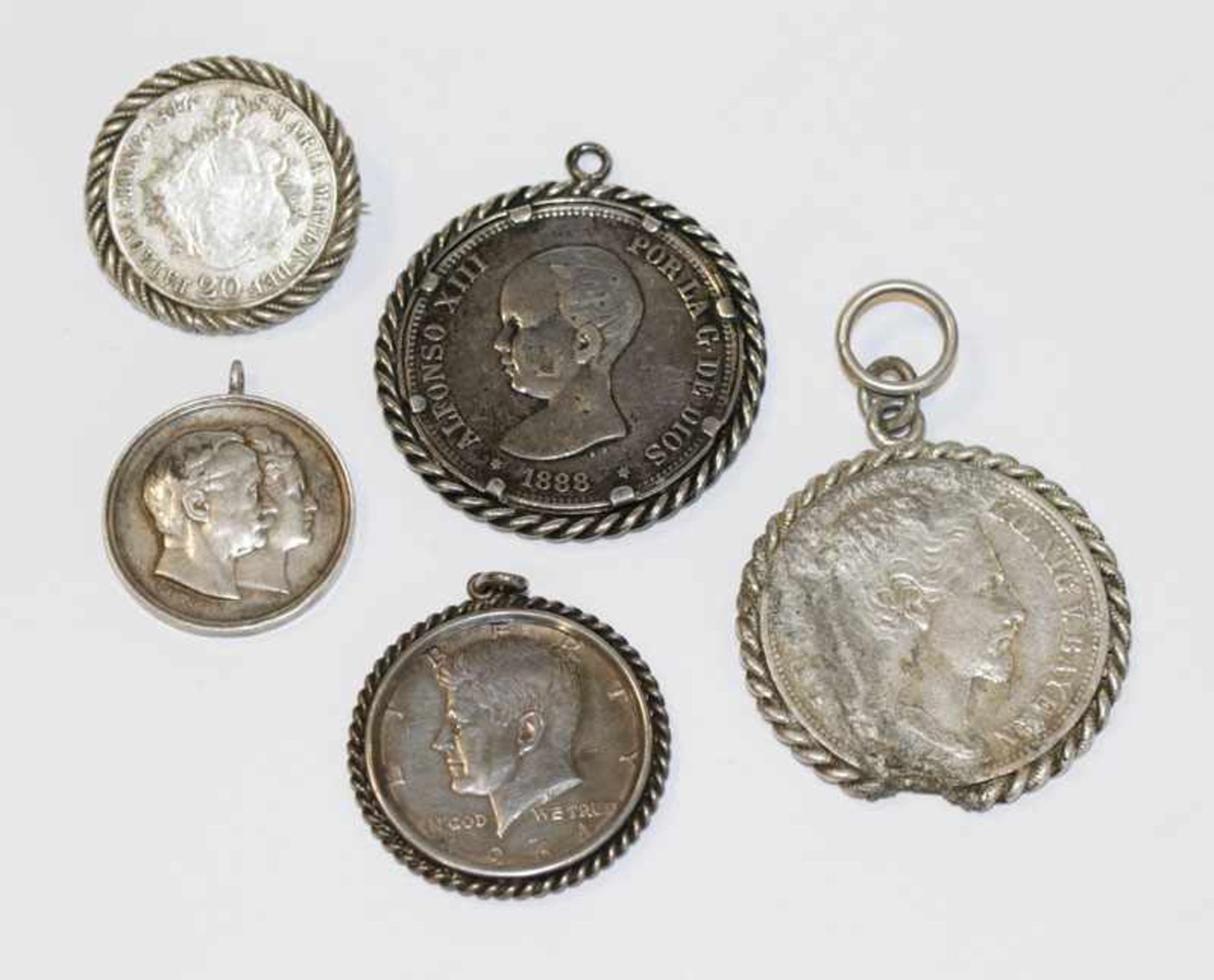 Konvolut von 5 gefaßten Silbermünzen, teils beschädigt, zus. 104 gr.