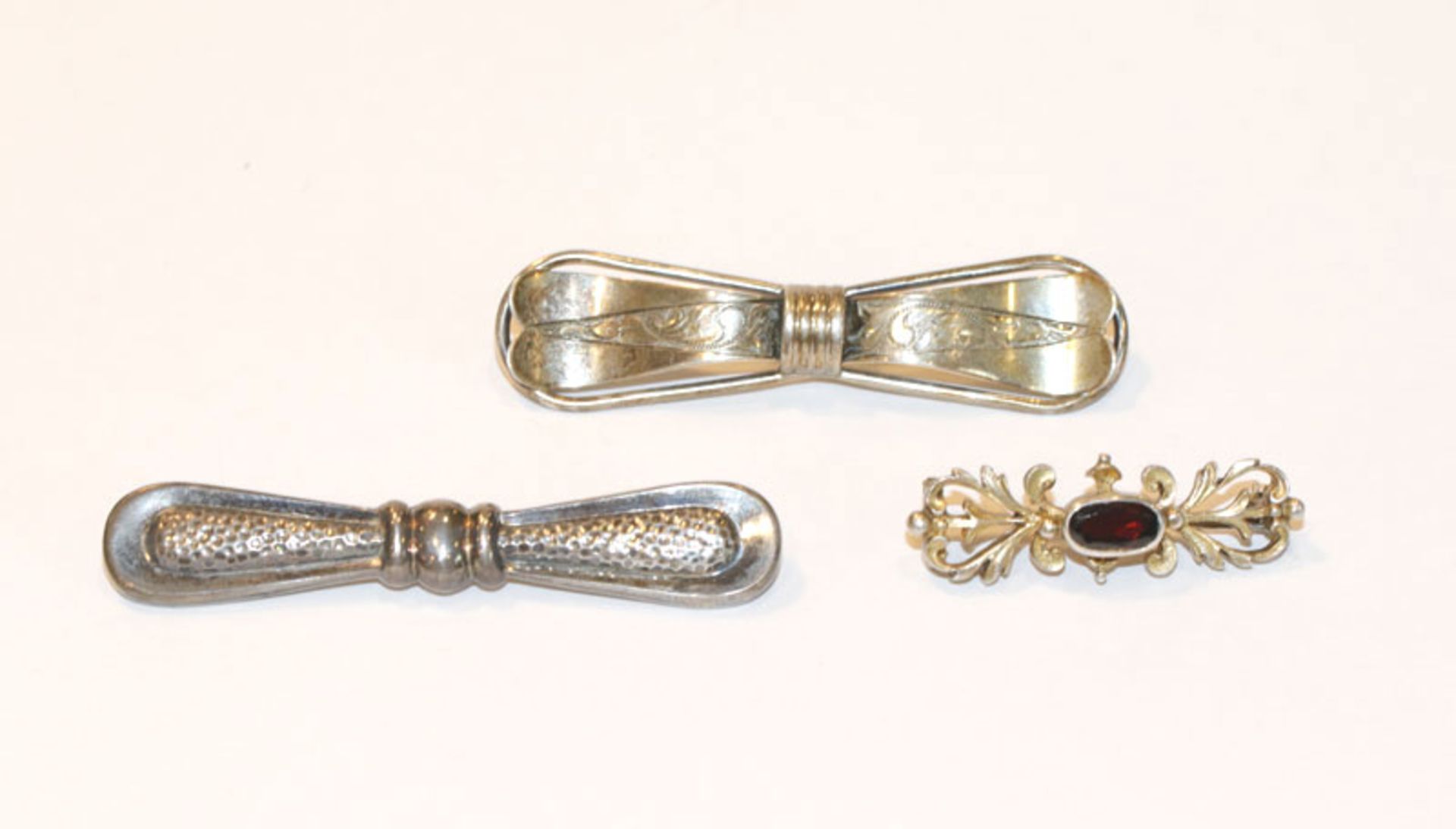 2 Silber Nadeln in Schleifenform, B 6/6,5 cm, und Silber Trachtennadel mit Granat, B 3,5 cm