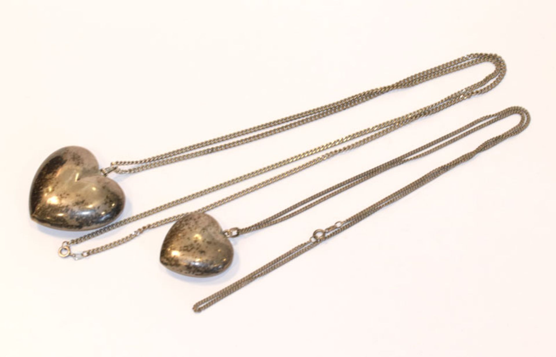 2 Silberketten, L 70/88 cm, mit 2 Herzanhänger, Tragespuren