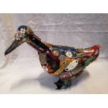 An American painted wooden duck with applique decoration of numerous household objects and labels,