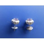 A pair of amethyst & diamond cluster earrings in '18k' white metal.