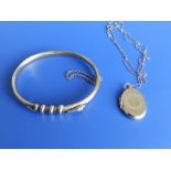 A yellow metal bangle - repaired and a locket on chain.