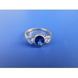 A three stone millegrain set sapphire & diamond ring, the central oval sapphire flanked by two