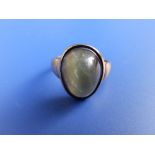 An oval domed cabochon quartz cat's eye ring in yellow metal. Finger size M.