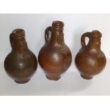 Three 17th/18thC stoneware bellarmines with bearded mask decoration - one handle and neck re-stuck