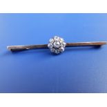 A yellow metal tie pin set with a diamond cluster.