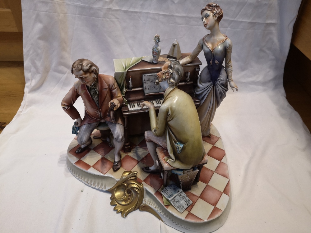 A large Capodimonte biscuit porcelain group by A. Borsato - Making music at the piano, 14" across.