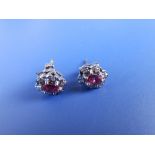 A pair of oval ruby & diamond cluster earrings.