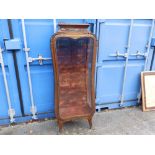 A small waisted vitrine with gilt metal mounts and three glass shelves.