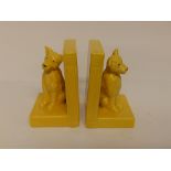 A pair of yellow glazed dog bookends.