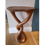 A modern hand-carved pedestal occasional table of rounded organic form, fashioned from a single