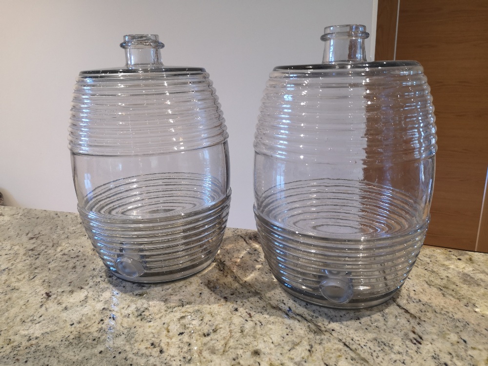 A pair of old moulded glass spirit barrels, 13.5" high.