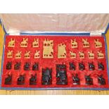 A 20thC Eastern carved wood chess set in case.