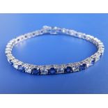 A sapphire & diamond set 750 white metal line bracelet set with 23 brilliant cut diamonds of total