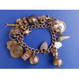 A gold charm bracelet including a sovereign.