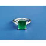 An emerald & diamond ring, the central rectangular cut emerald weighing approximately 2.8 carats