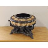 A circular quillwork bowl on carved elephant stand.
