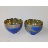 A pair of small silver lustre studio pottery bowls , the lustre interiors dripping over onto