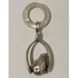 A silver & mother-of-pearl baby's rattle in the form of a chick perched in a wishbone, Chester